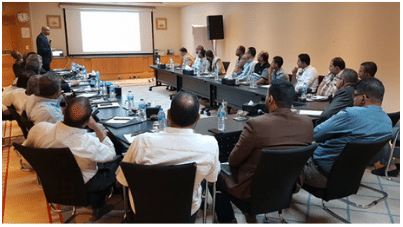 image of people at a table listening to presentatoin